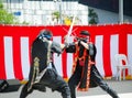 Ninja cosplay in fighting performance with sword skill on the stage at Matsuri Japanese festival.